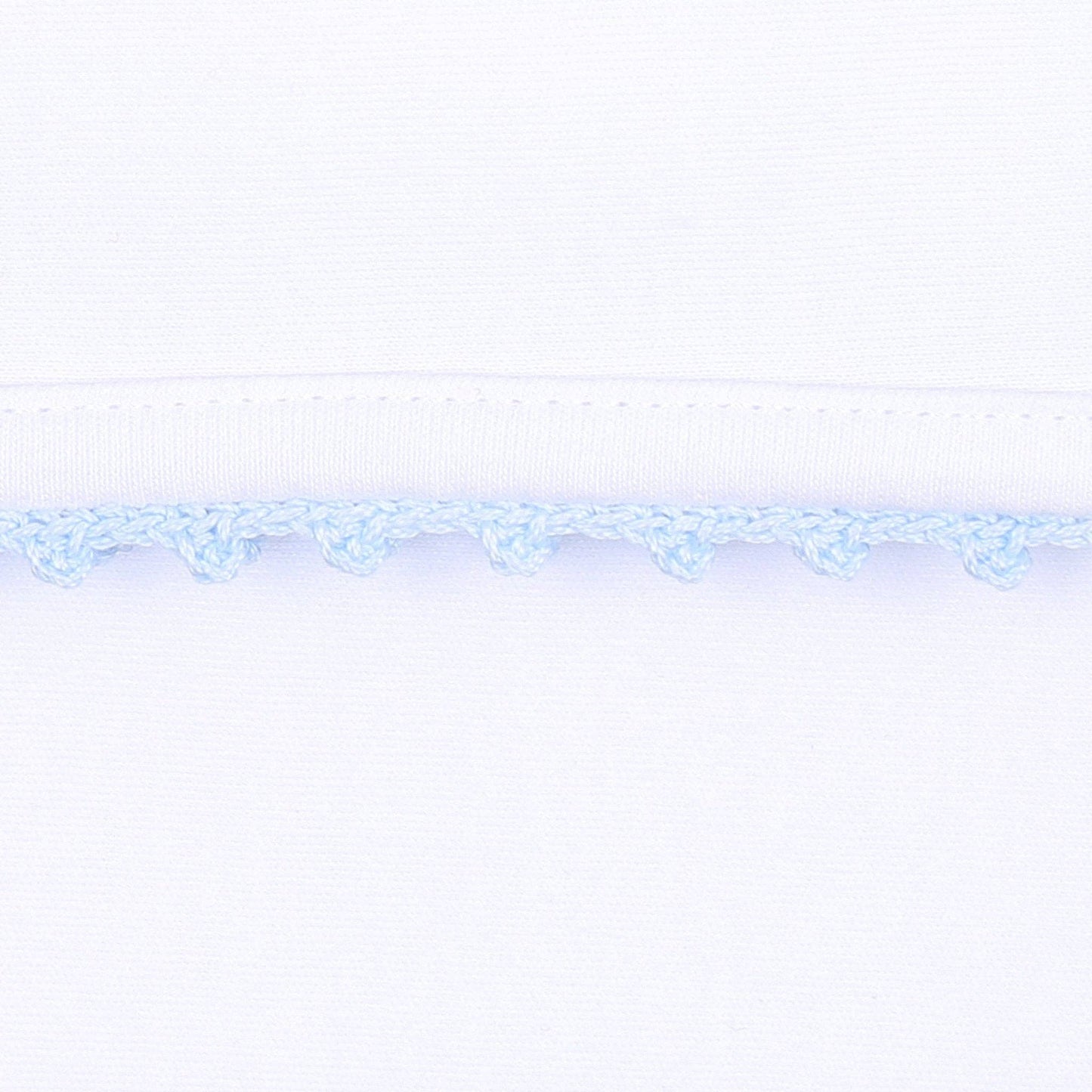 Baby boy white hat with blue crochet trim on white background