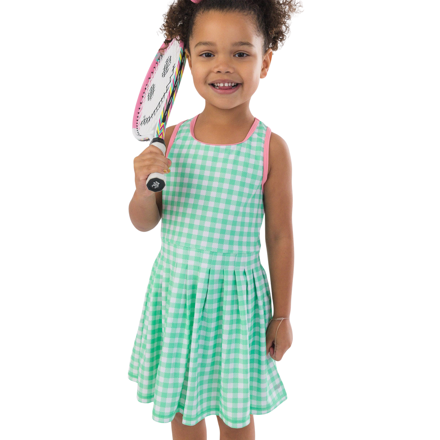 Child in a green checkered dress holding a tennis racket on a white background