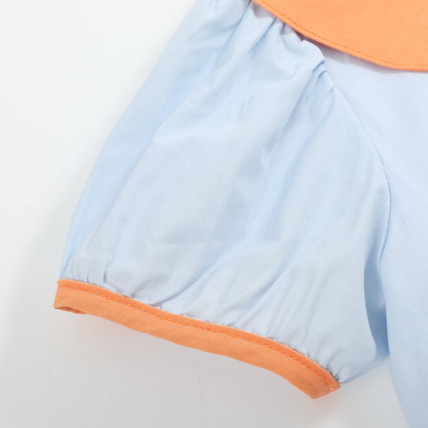 Light blue dress with orange trim on a light gray background