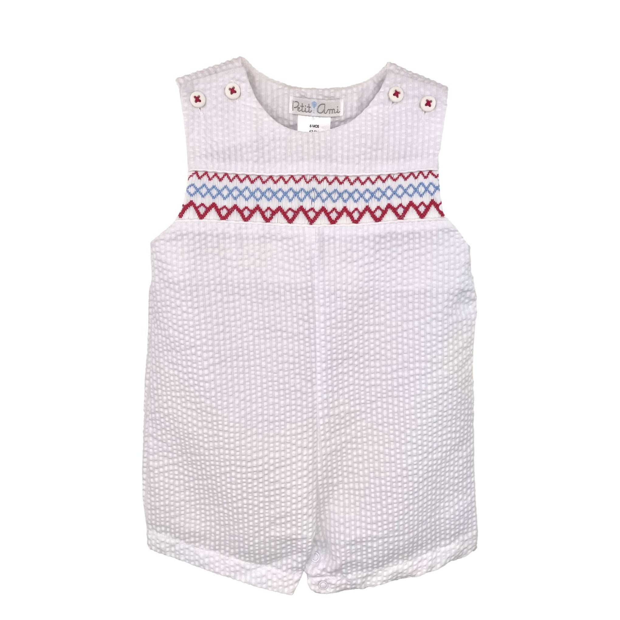 White baby romper with red and blue smocking on a white background
