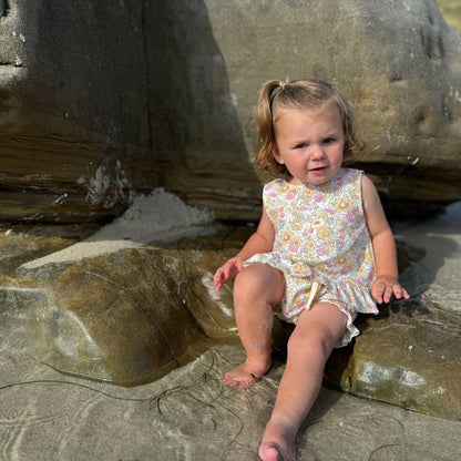 Child sitting on rocks at a beach