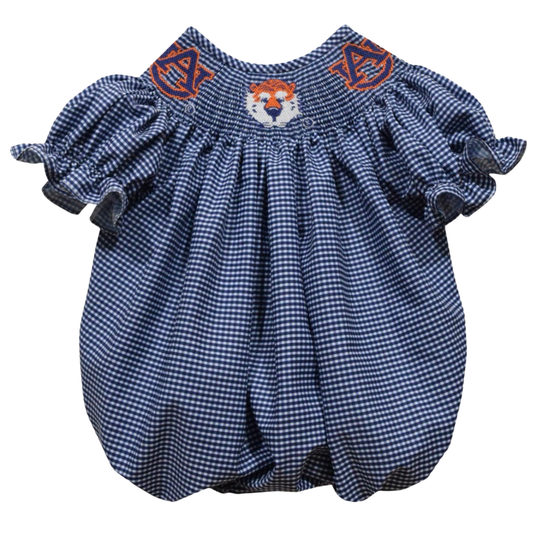 A navy and white gingham baby bubble romper with short ruffled sleeves, featuring orange embroidered tiger head details on the chest and a white embroidered tiger face in the center.