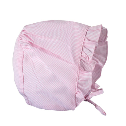 Pink baby bonnet with ruffles on a white background
