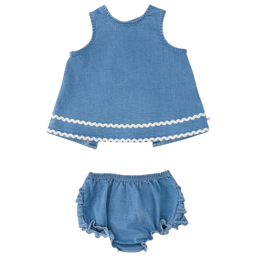A two-piece baby outfit set in light blue denim-like fabric, featuring a sleeveless top with a white wavy trim at the hem and matching ruffled bloomers, displayed on a solid white background.