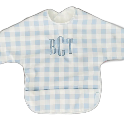 Baby bib with blue and white checkered pattern and 'BCT' monogram on a white background