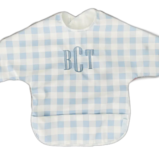 Baby bib with blue and white checkered pattern and 'BCT' monogram on a white background
