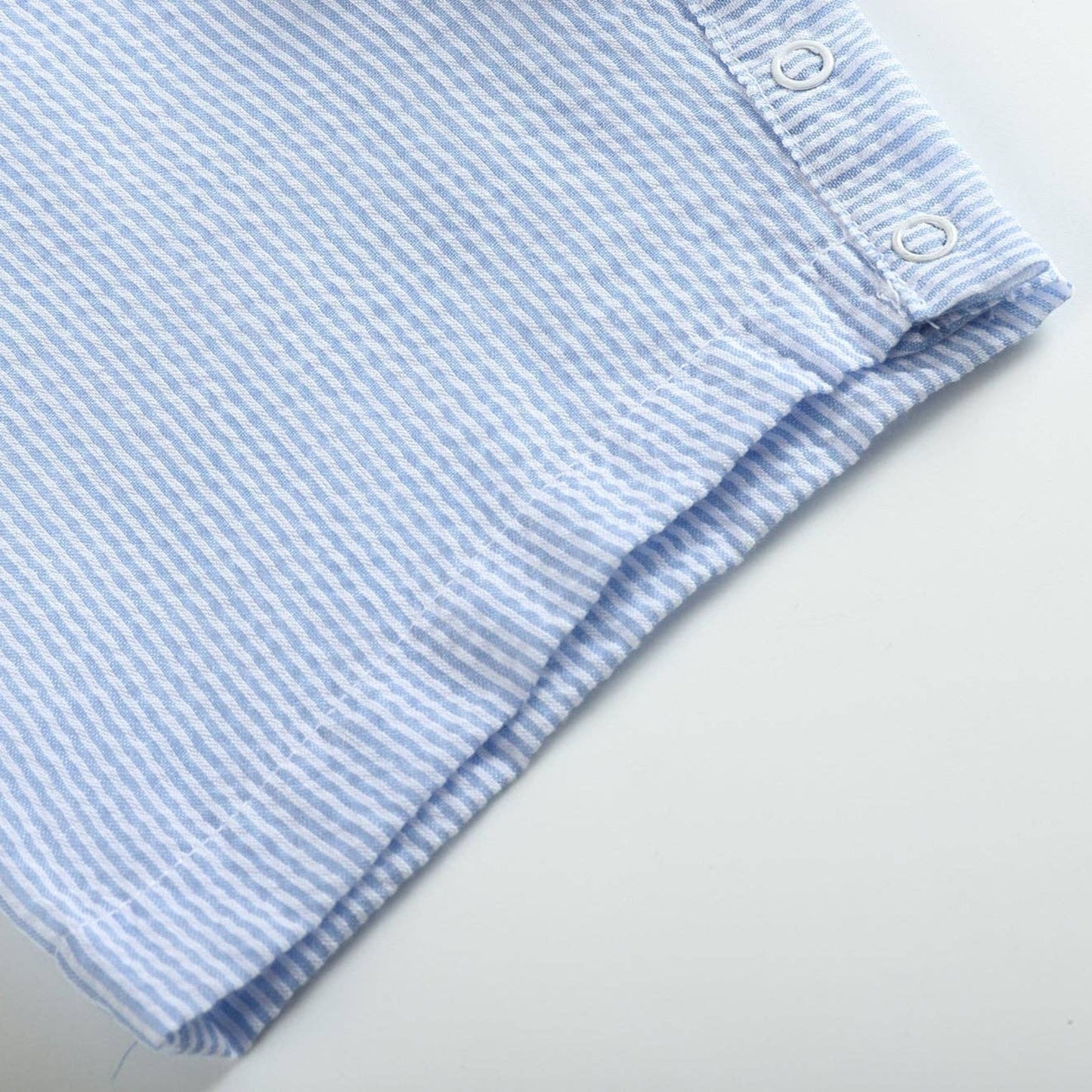 Folded blue and white striped fabric on a light gray background