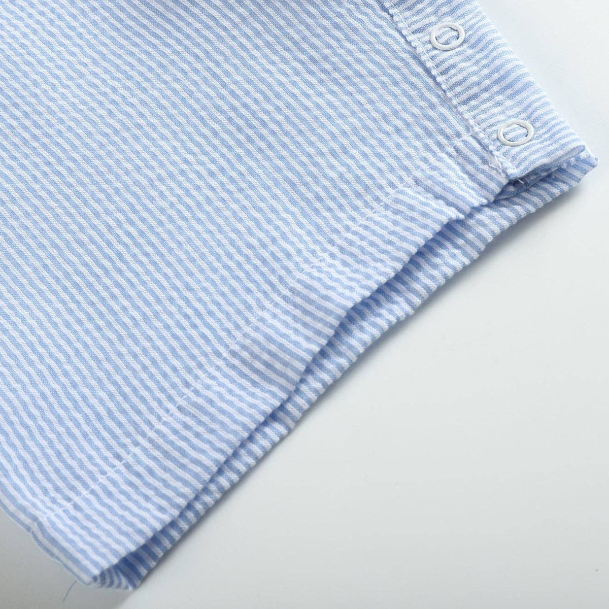 Folded blue and white striped fabric on a light gray background