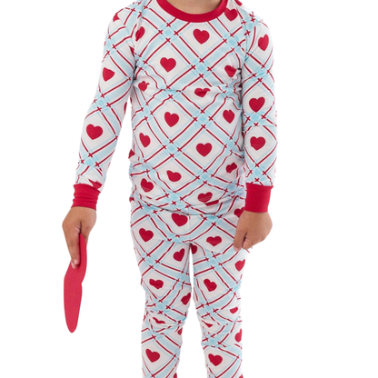 Children's pajama set with heart and arrow pattern on a white background