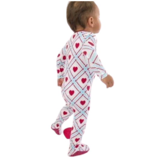 Baby wearing a heart-patterned onesie on a white background
