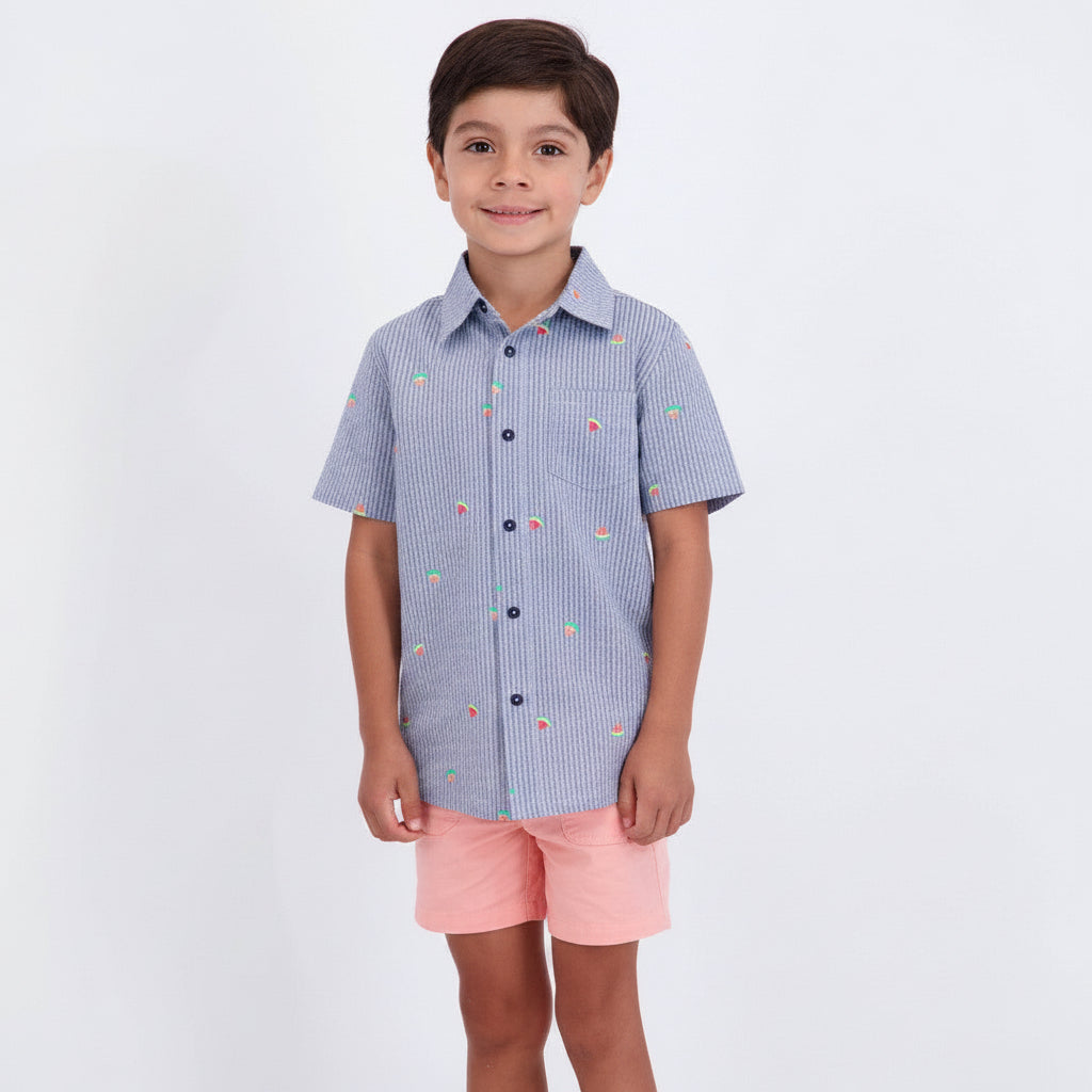Child wearing a blue checkered shirt and pink shorts on a white background