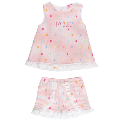 Children's pink dress with colorful patterns and white ruffles on a white background