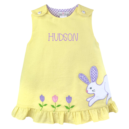 Yellow dress with bunny and flower design and 'Hudson' text on a white background