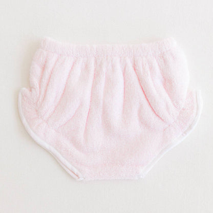 Pink baby bloomers on a light gray background