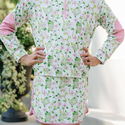 Person wearing a floral dress with pink trim outdoors.