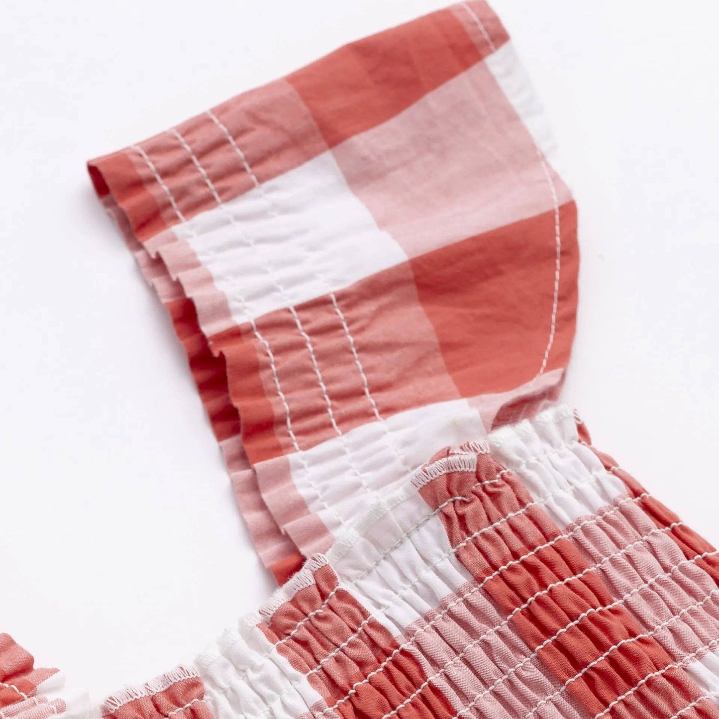 Red and white checkered fabric with a textured pattern on a white background