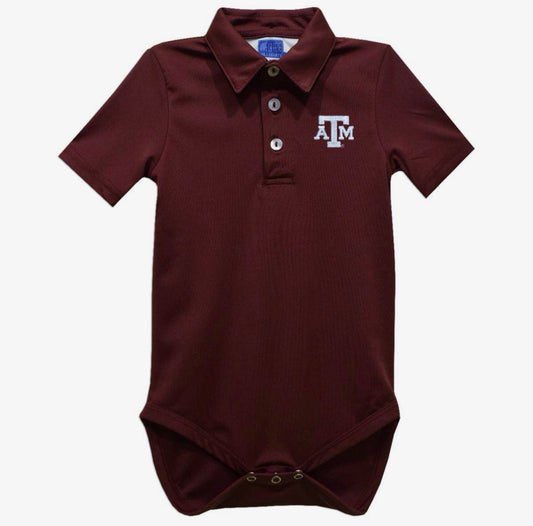 A baby short-sleeve polo bodysuit in maroon with a white embroidered 'A&M' logo on the left chest, featuring a three-button placket and snap closures at the crotch.