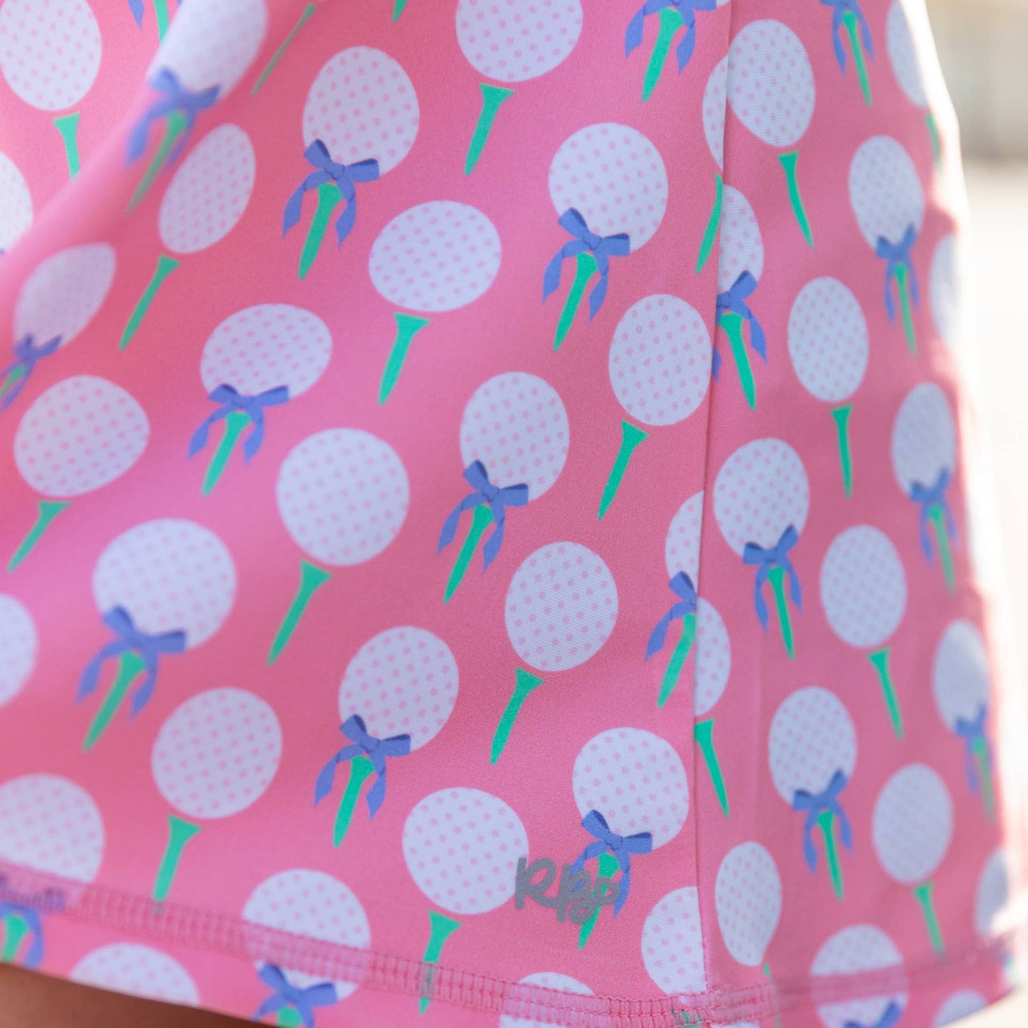 Pink skirt with golf ball and bow pattern on a blurred background