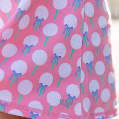 Pink skirt with golf ball and bow pattern on a blurred background