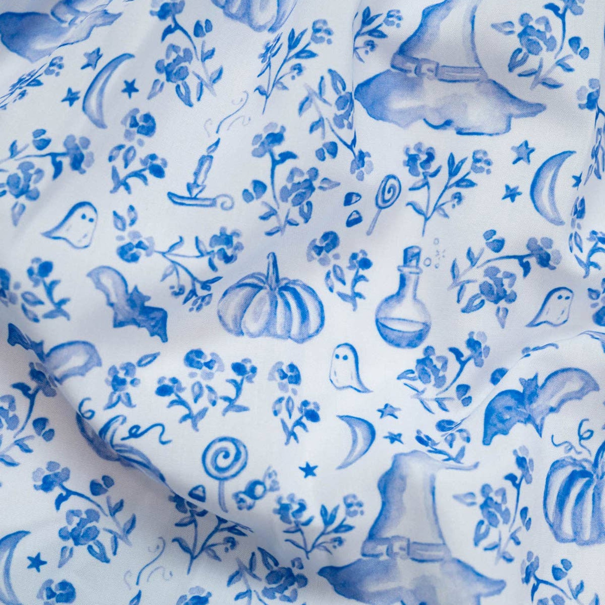 Blue floral and nature-themed pattern on white fabric