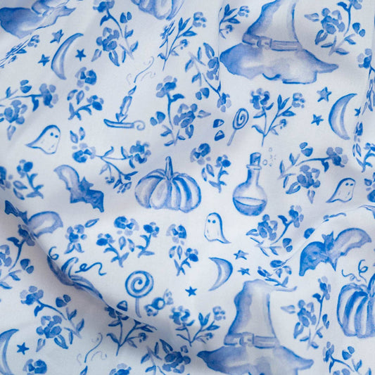 Blue floral and nature-themed pattern on white fabric