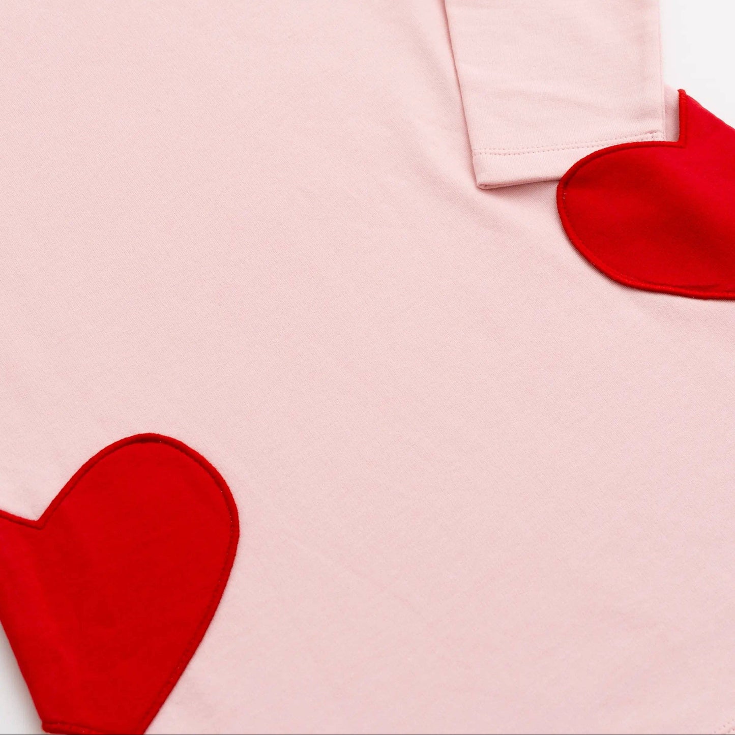 Pink dress with red heart shapes on a white background