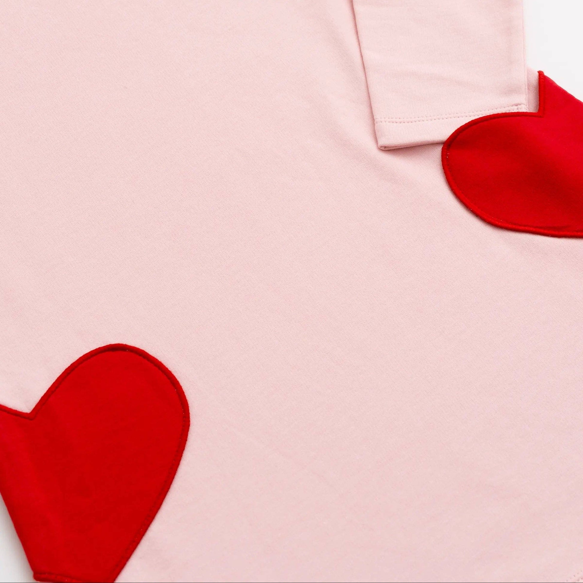 Pink dress with red heart shapes on a white background