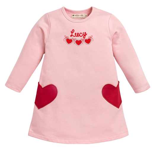 Pink dress with red heart designs and 'Lucy' text on a white background