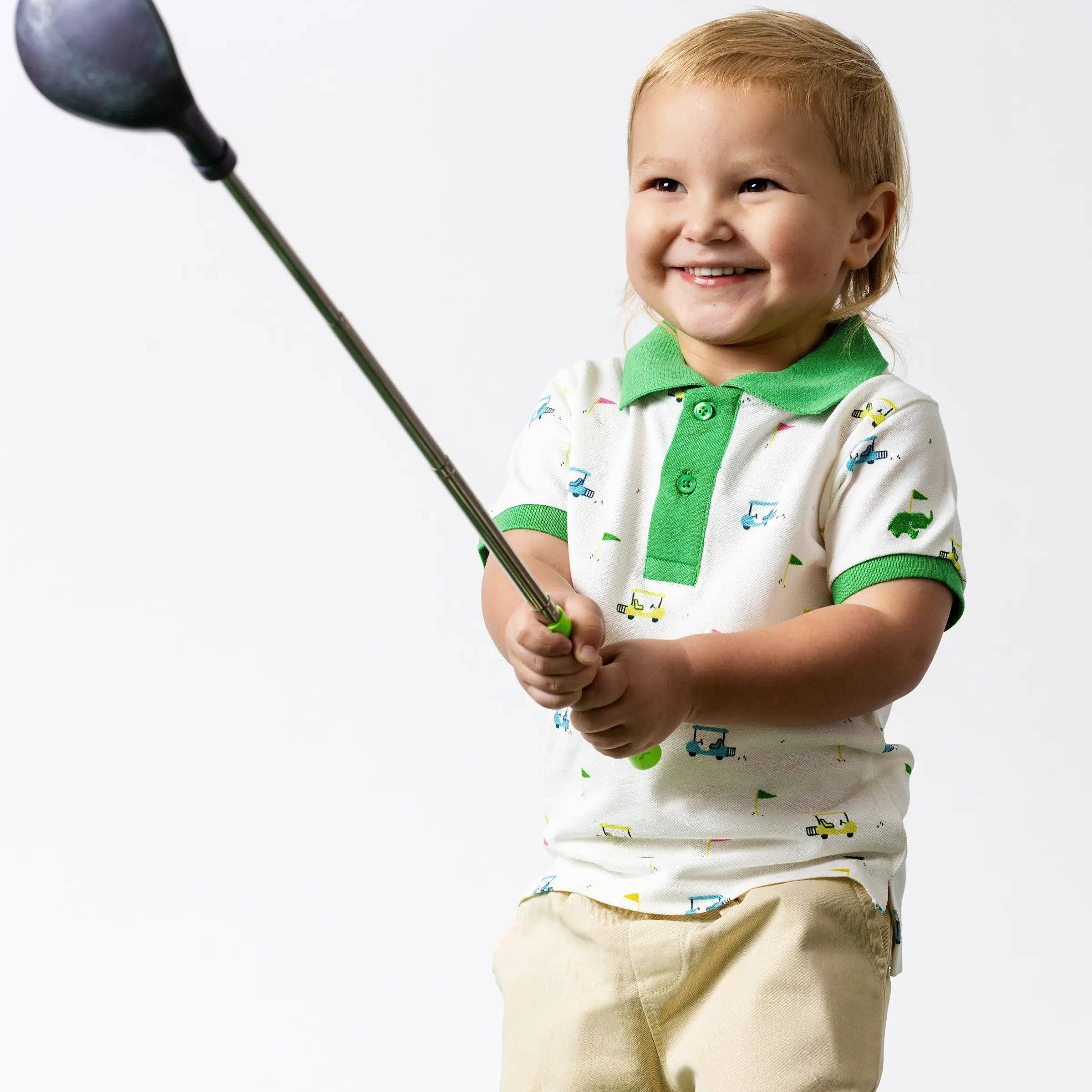 Child holding a golf club against a white background