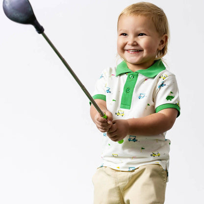 Child holding a golf club against a white background