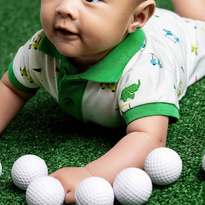 Baby lying on grass with golf balls around wearing Green polo collared golf cart Romper