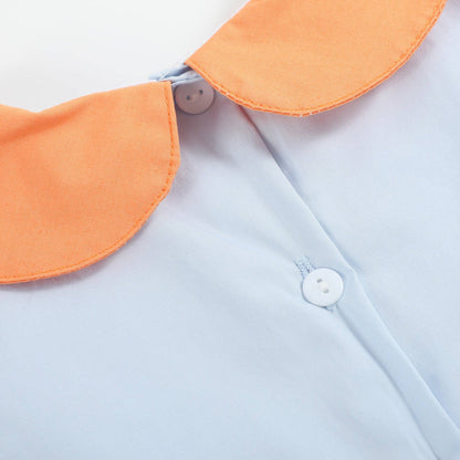 Close-up of a light blue shirt with an orange collar and buttons.