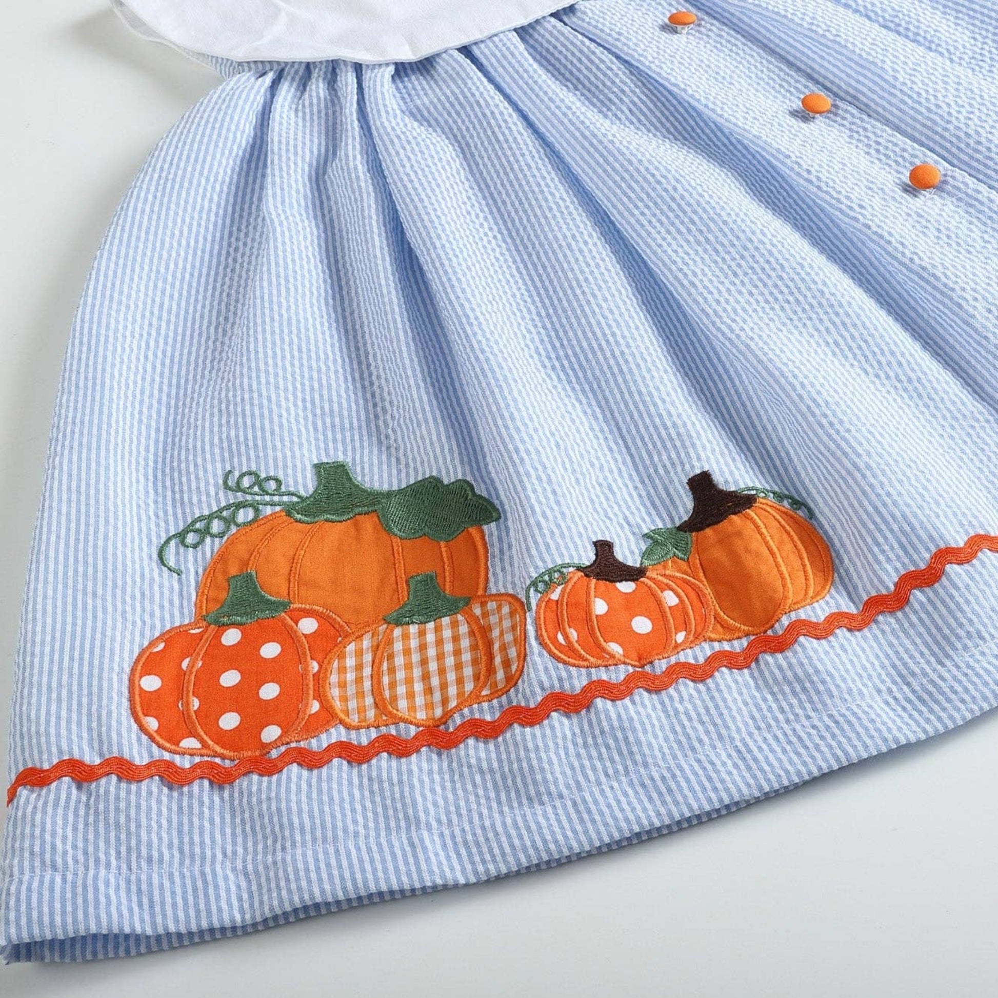 Light blue dress with embroidered pumpkins on a white background
