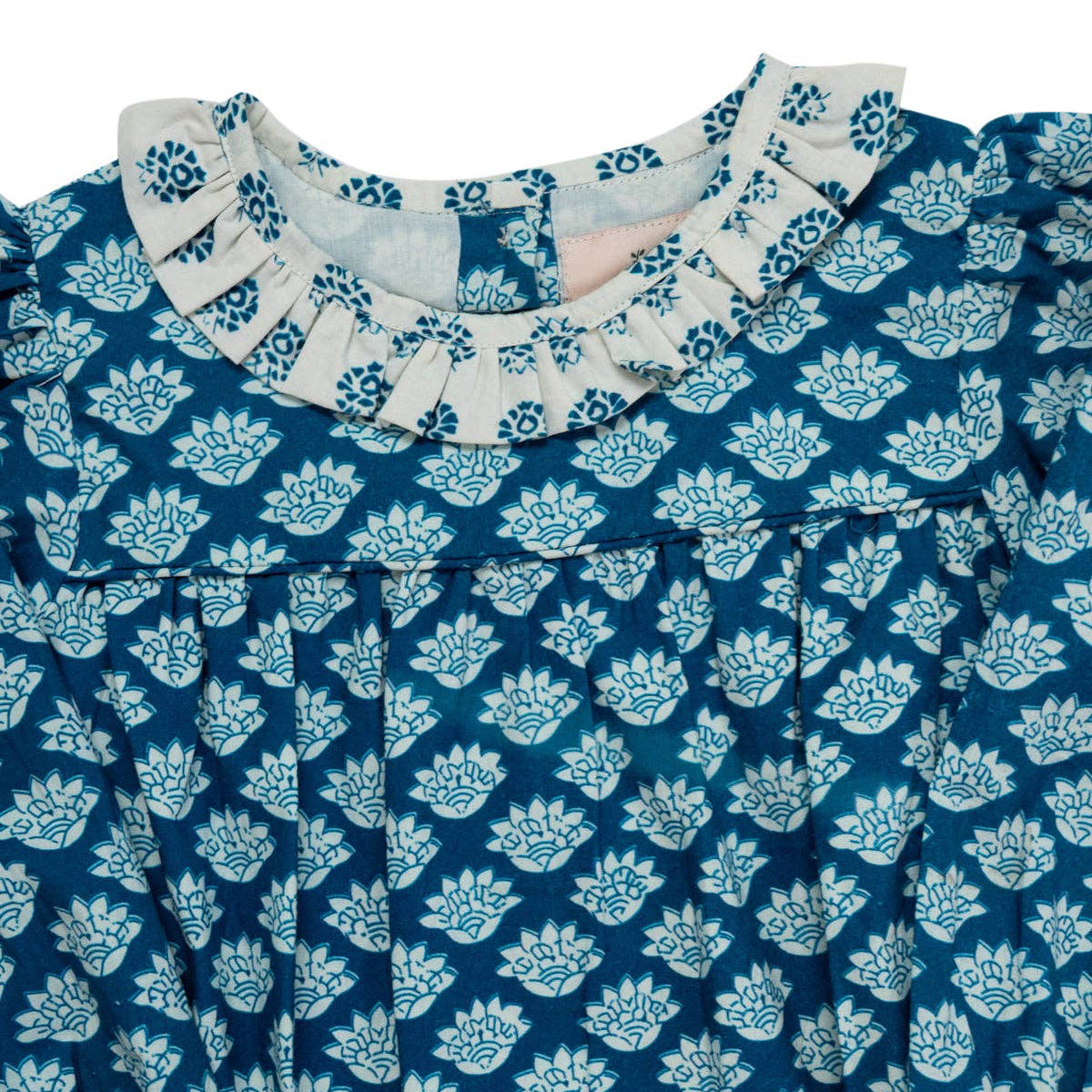 Blue and white patterned dress with ruffled collar on a white background