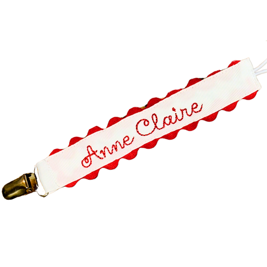 White Paci clip with red scallop on a white background
