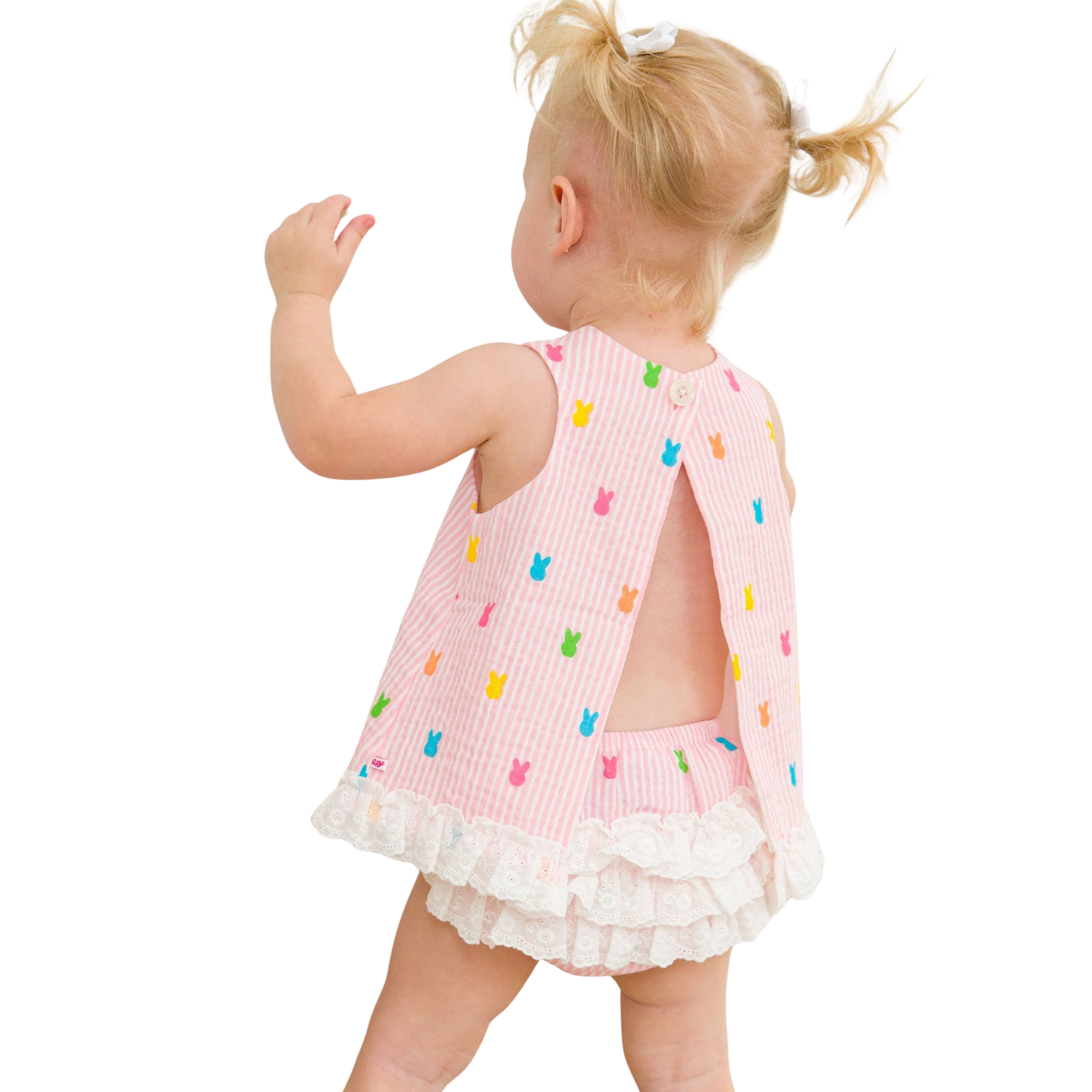 Child wearing a pink dress with colorful back design on a white background
