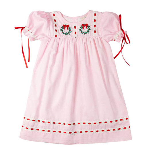 Pink dress with red trim and embroidered details on a white background