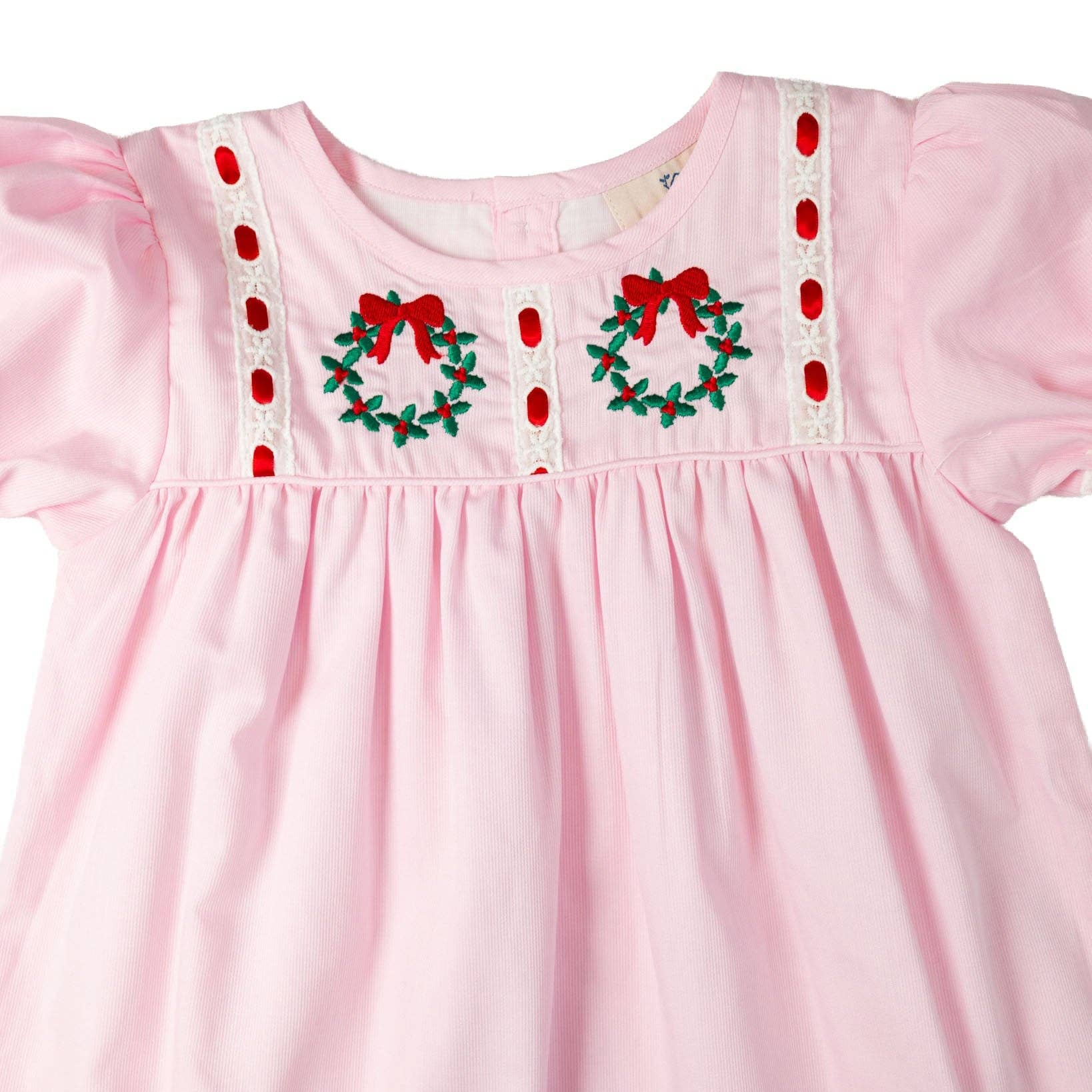 Pink dress with Christmas wreath embroidery on a white background