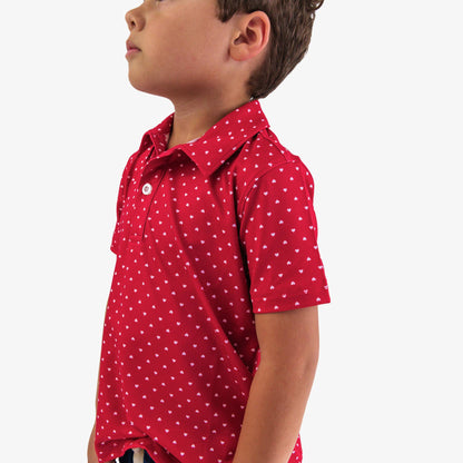 Child wearing a red polka dot shirt on a white background