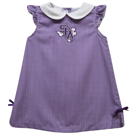 A purple and white gingham dress for toddlers, featuring a white Peter Pan collar, ruffled cap sleeves, side ties, and a purple and white Texas Longhorns 'SFA' logo on the chest.