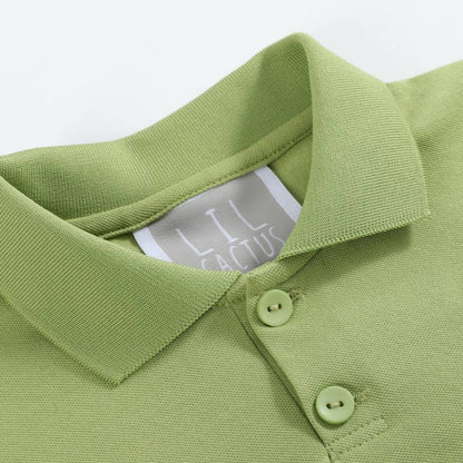 Green polo shirt with a small embroidered design on a white background