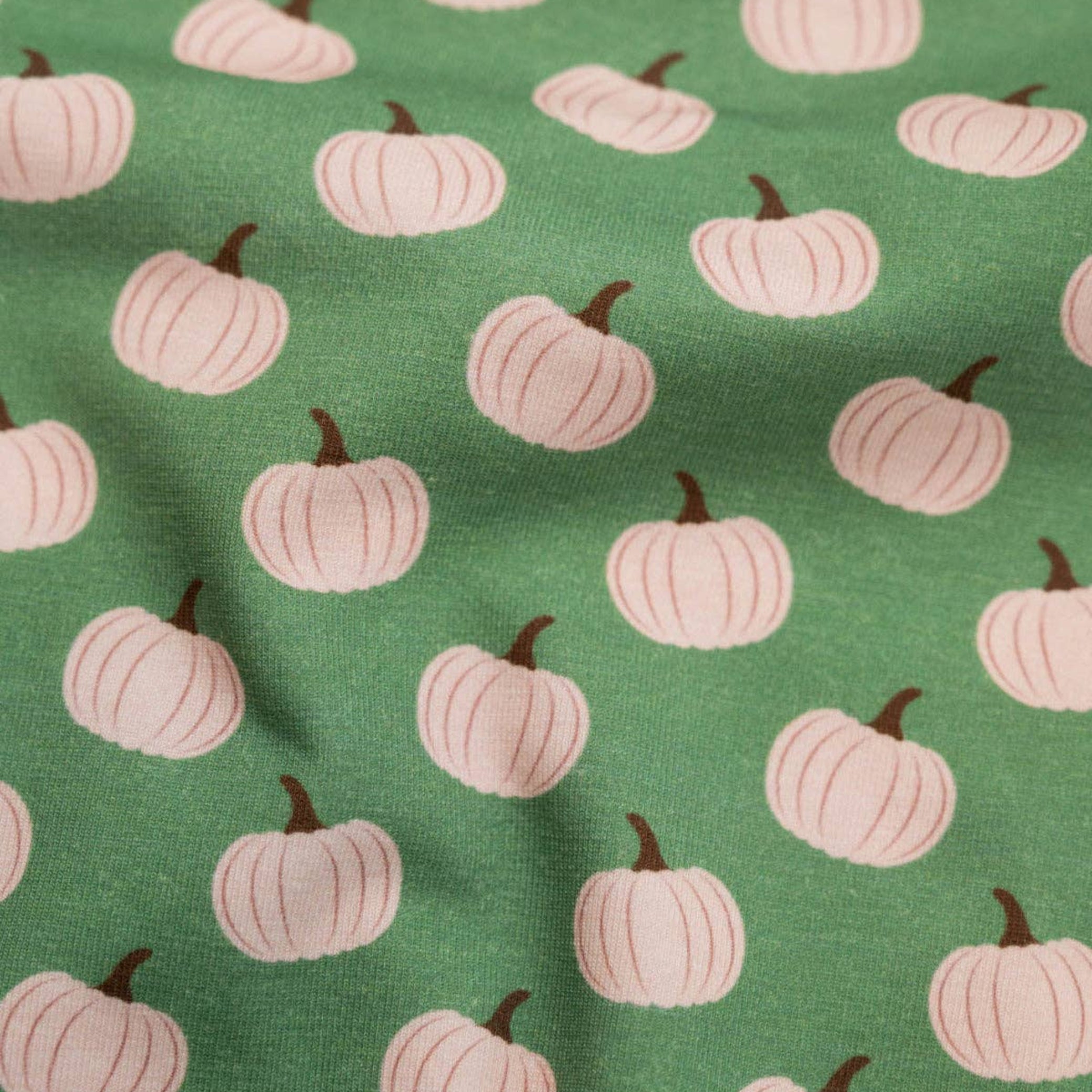 Pattern of white pumpkins on a green background