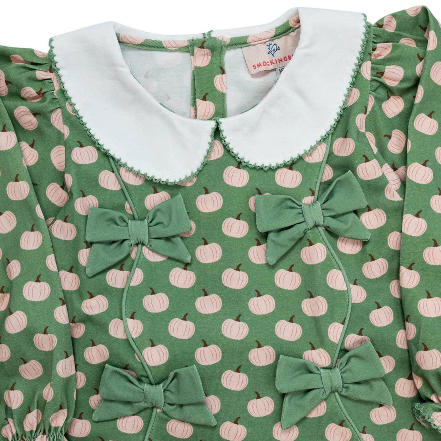Green dress with pink pumpkin pattern and white collar, featuring a brand label.