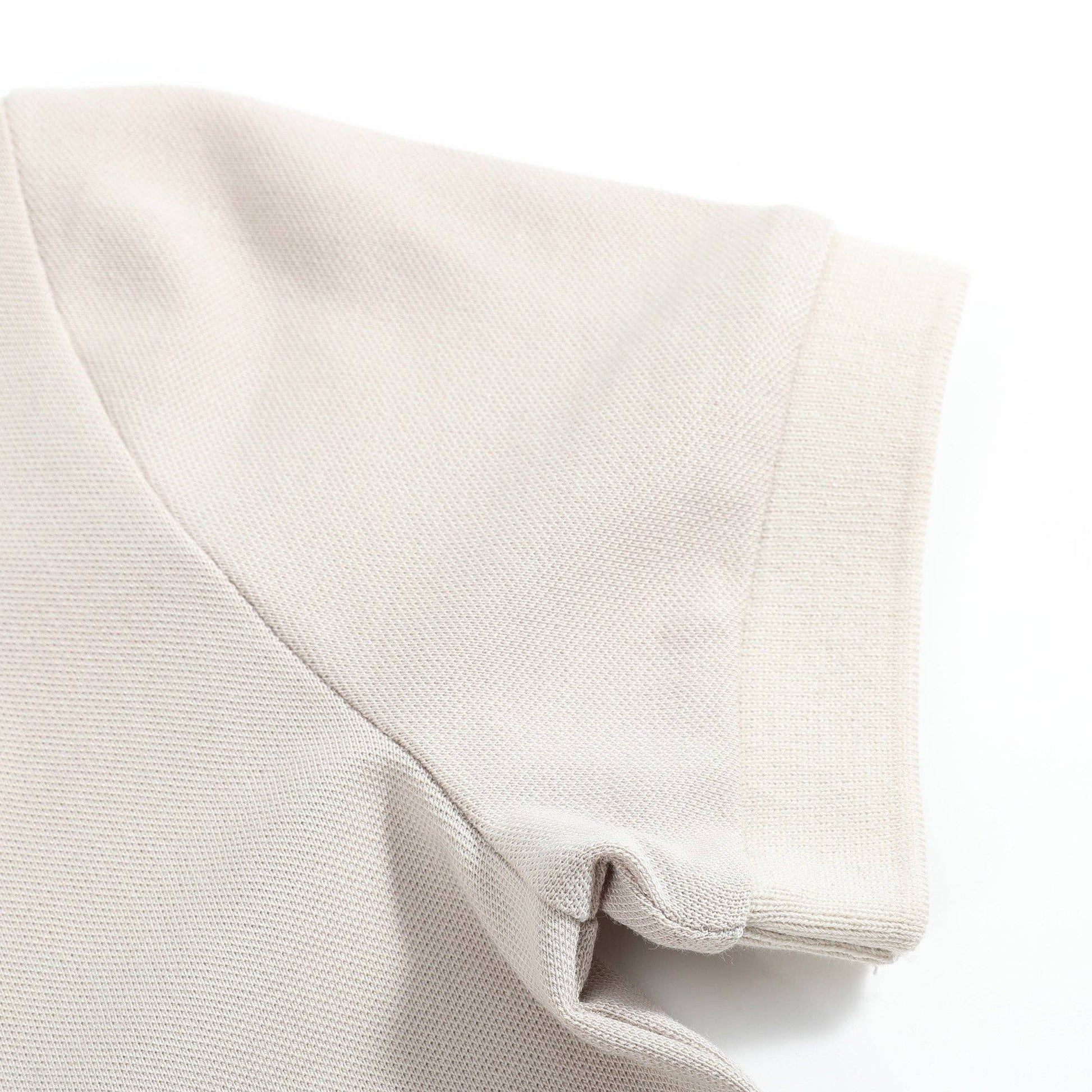 Folded beige fabric with a small embroidered train design on a white background