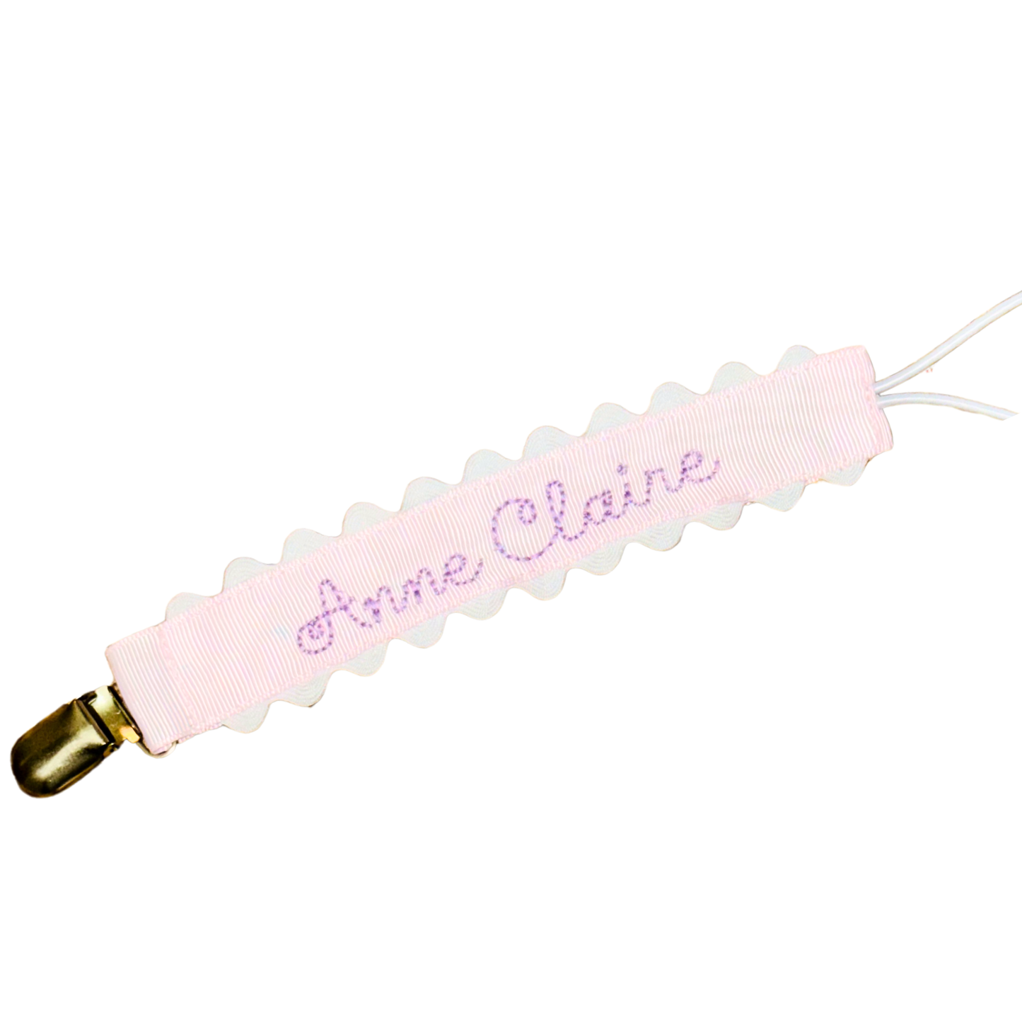 Pink paci clip with white scalloped edges on a white background