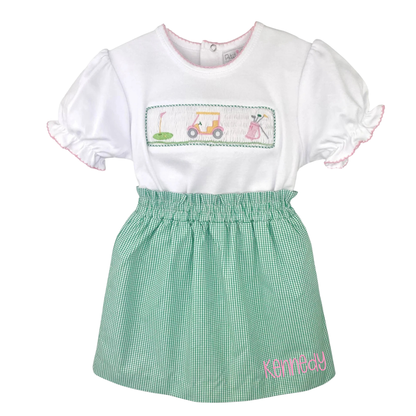 White top with embroidered design and green checkered skirt on a white background