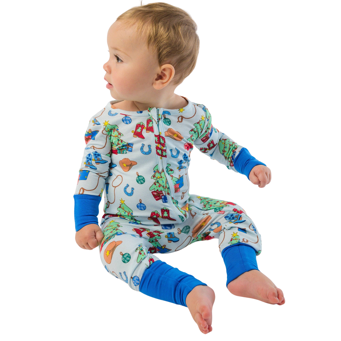 Baby wearing colorful pajamas with western Christmas pattern on a white background