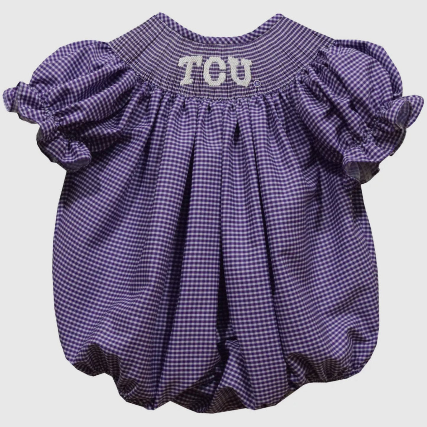 Purple checkered baby romper with 'TCU' text on a light gray background