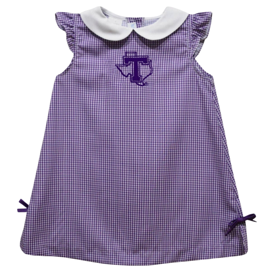 A purple and white gingham baby dress with a white Peter Pan collar, ruffled cap sleeves, and a purple embroidered Texas Longhorns logo on the chest.