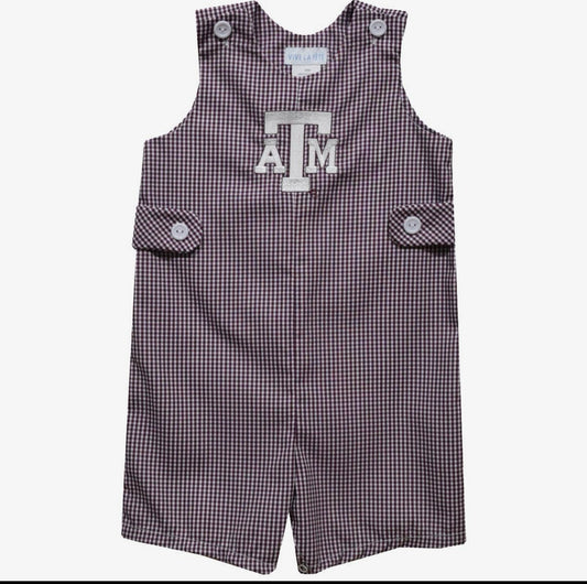 A sleeveless baby romper in a small gingham check pattern of dark purple and white, featuring a large white 'A&M' logo on the chest, buttoned shoulder straps, and side flap pockets.